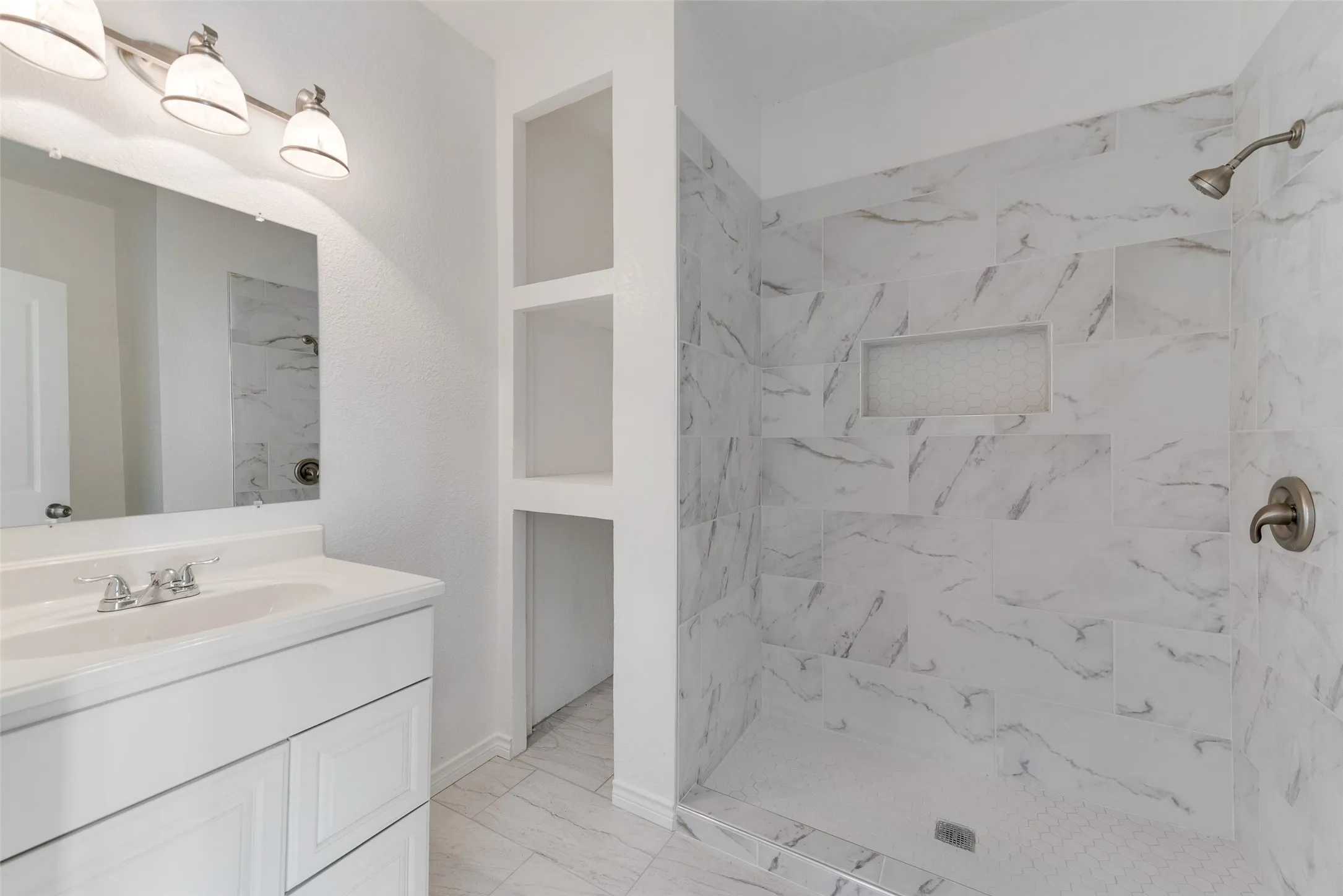 White vanity with an integrated sink and brushed nickel faucet