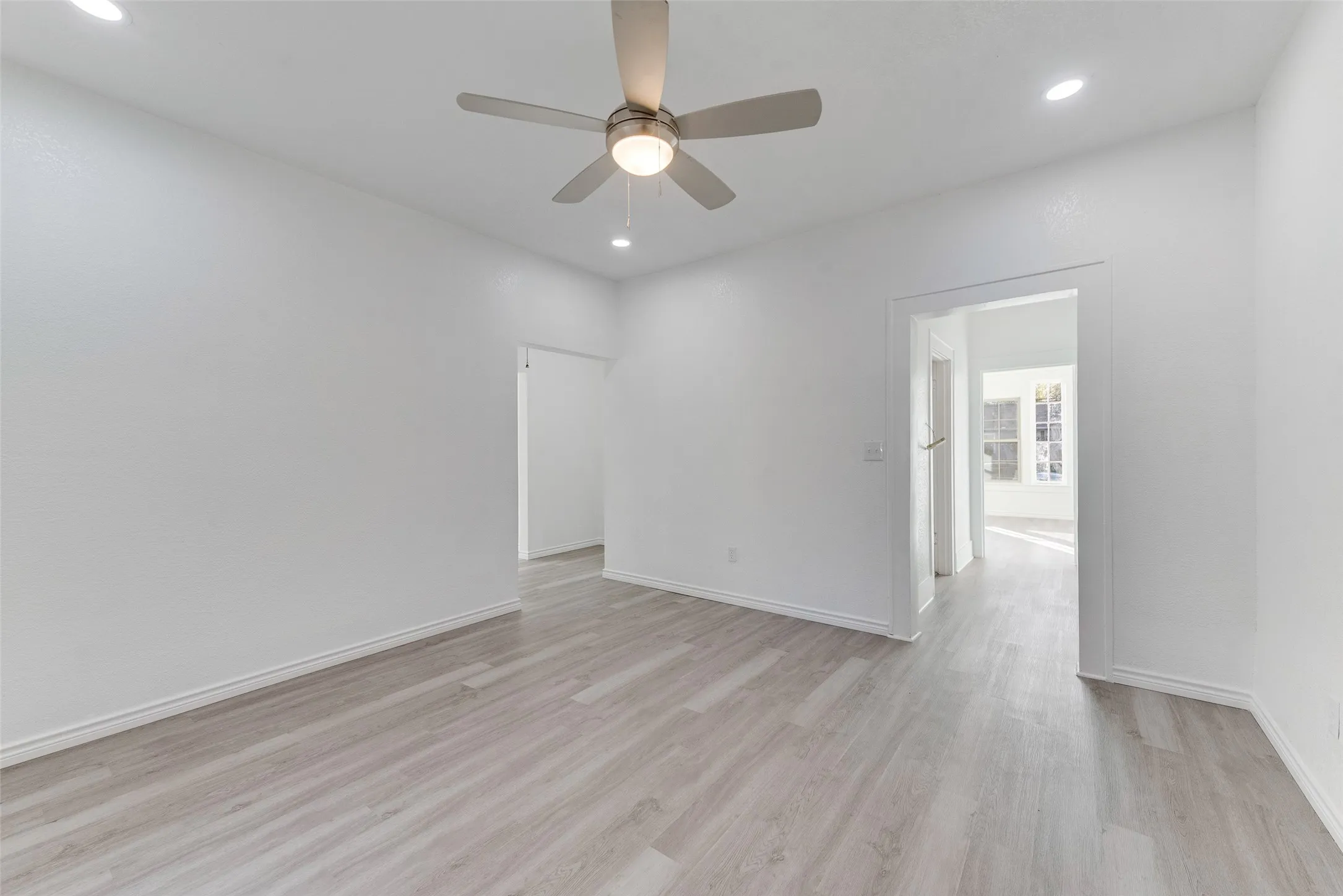 Recessed lighting, wood-finish flooring, ceiling fan, and white walls