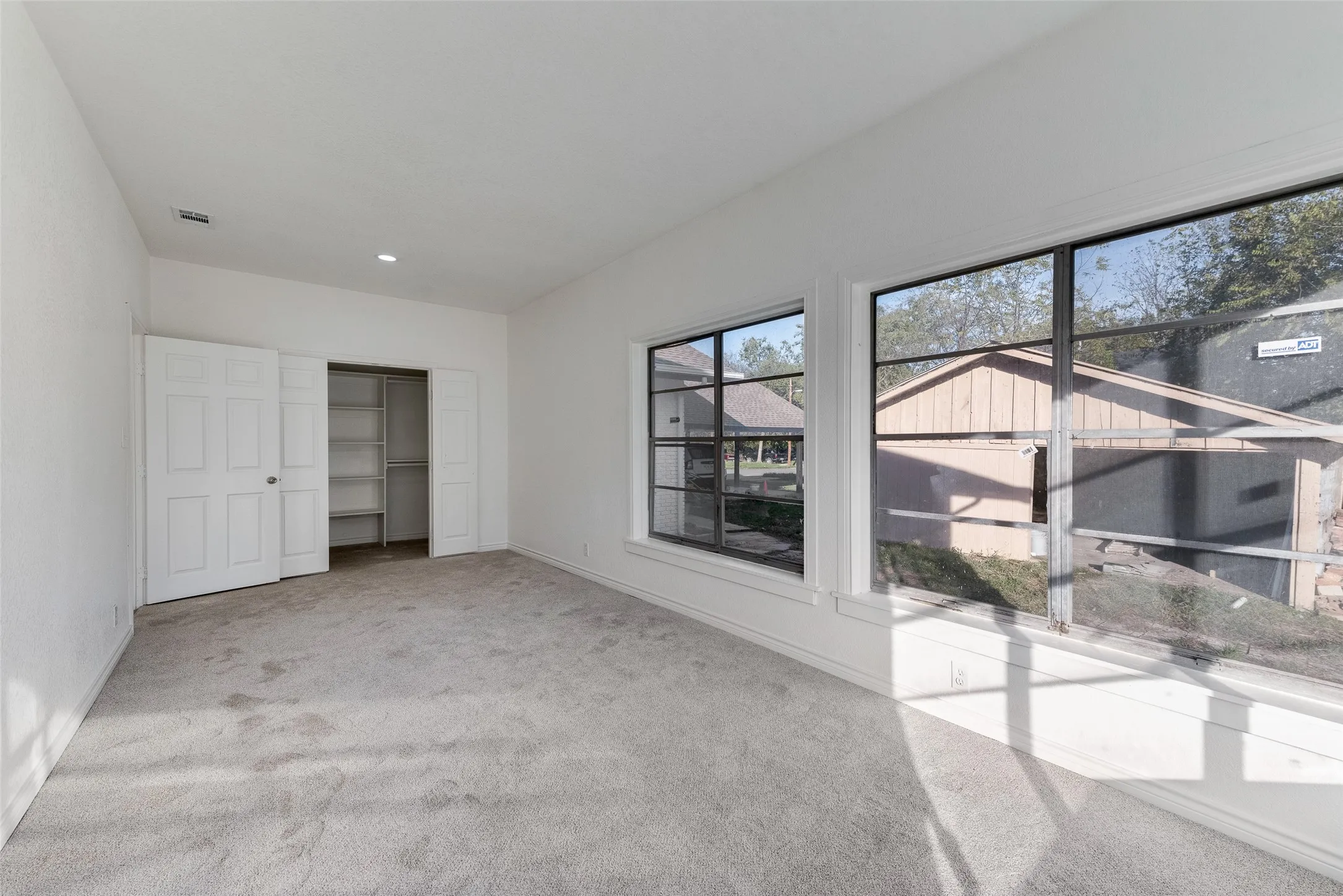 Neutral wall tones, recessed lighting, and carpeted flooring