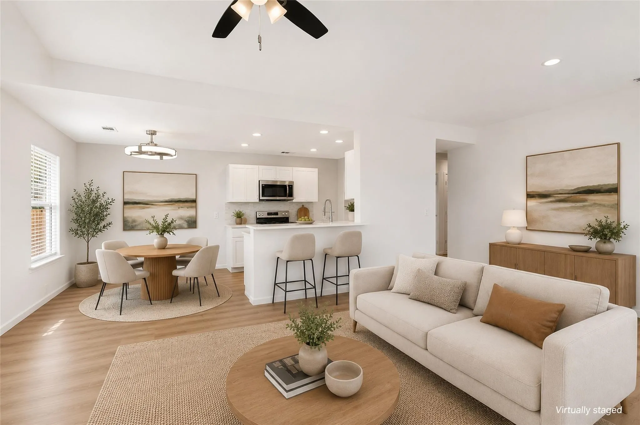 Open-concept living area with wood-finish flooring, white walls, and recessed lighting