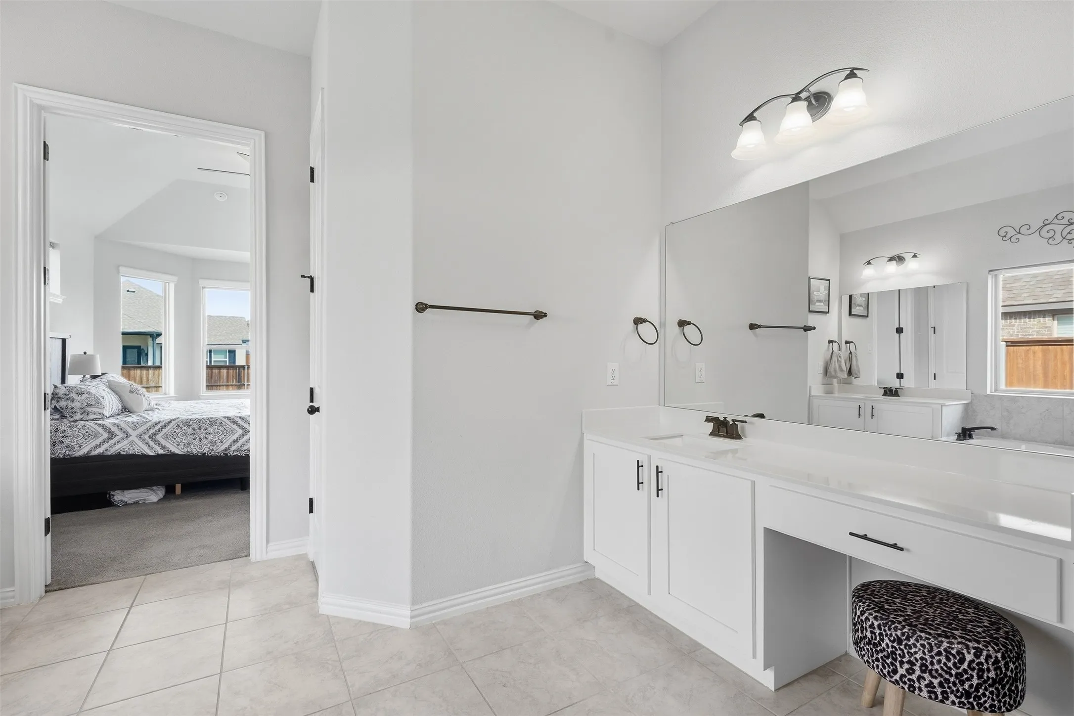 White cabinetry with dark hardware and a vanity area