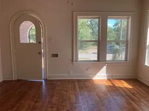 Foyer featuring plenty of natural light, arched walkways, and wood finished floors