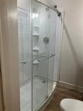 Bathroom featuring a shower stall and wood finished floors