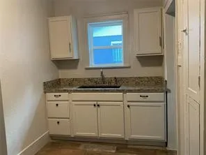 Kitchen with a sink and white cabinetry