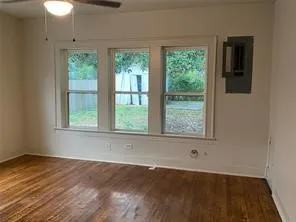 Unfurnished room with electric panel, ceiling fan, and wood finished floors