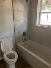 Bathroom with toilet and bathtub / shower combination