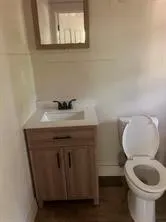 Half bathroom featuring vanity and toilet