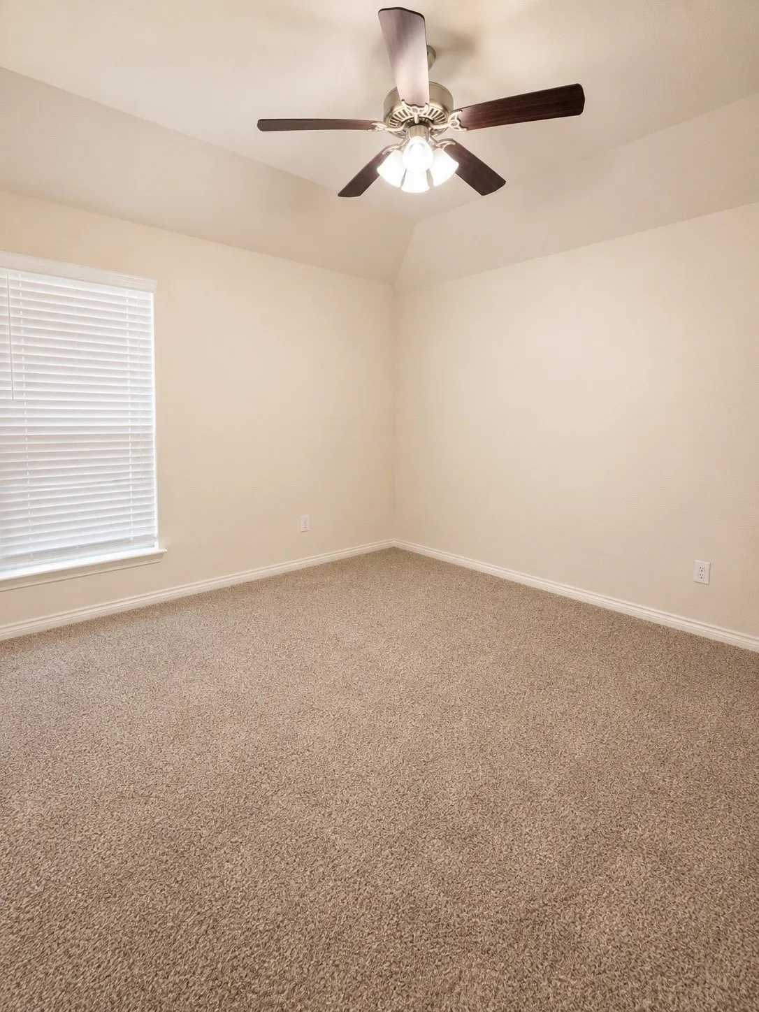 Vaulted ceiling with a ceiling fan and light fixture, carpeted flooring, and window with blinds