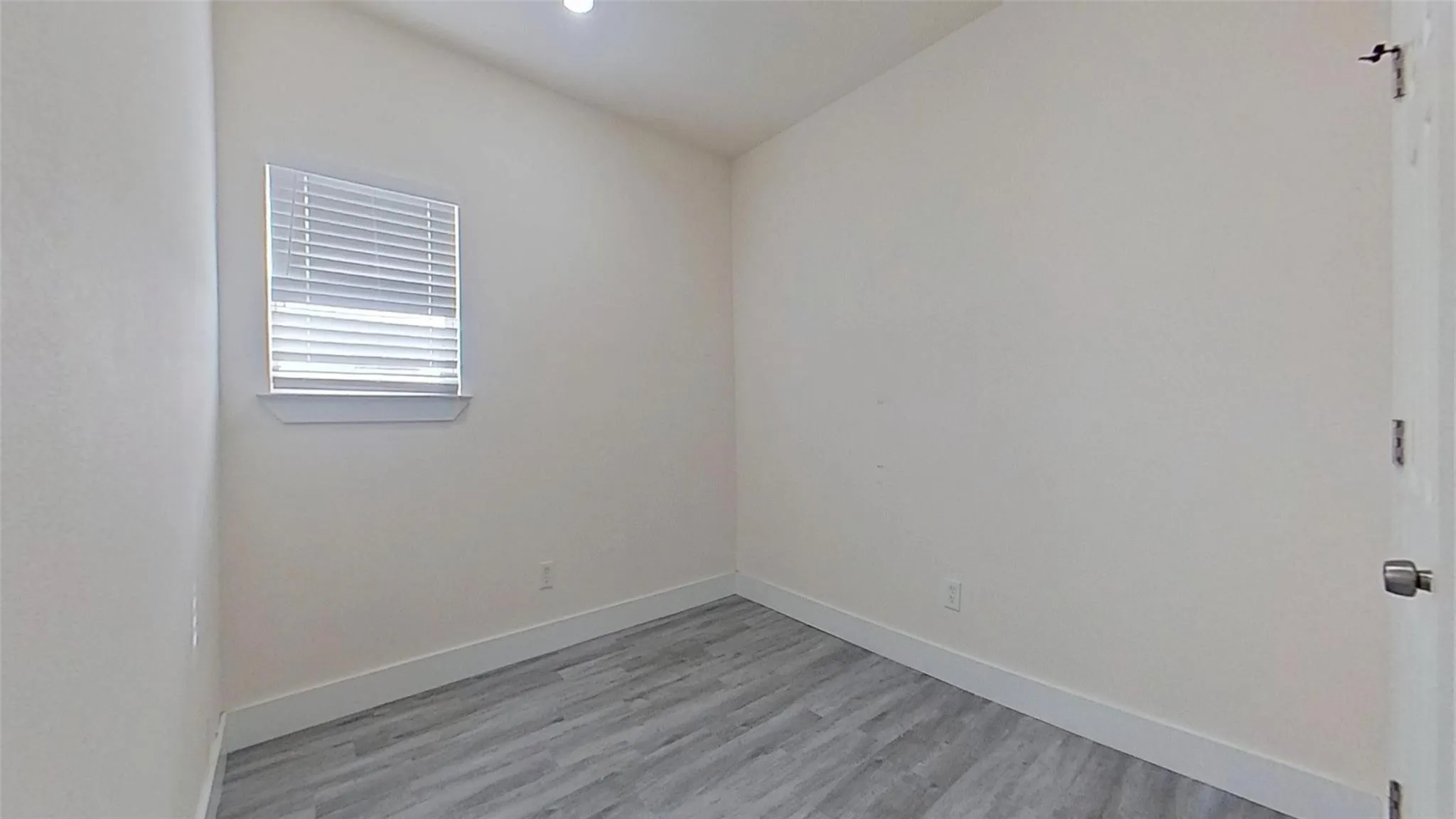 Light-toned walls, wood-finish flooring, and recessed lighting