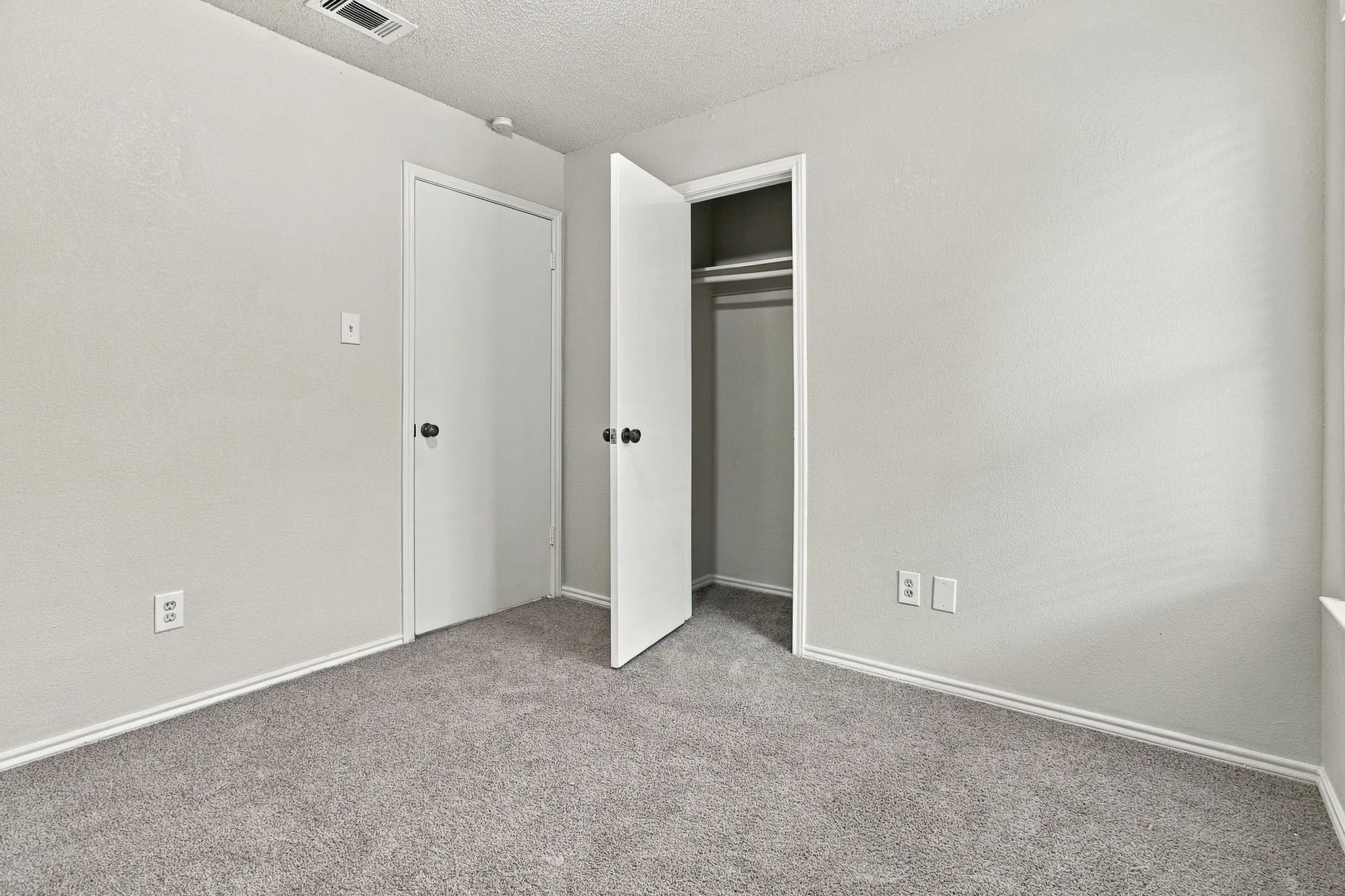 Neutral wall finishes with carpeted flooring
