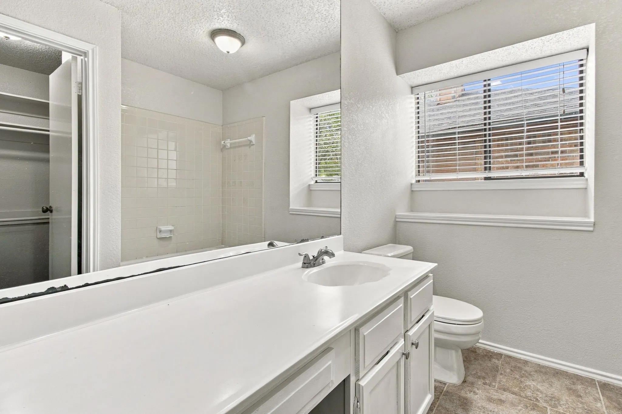 White vanity with integrated sink, chrome faucet, and storage​​‌​​​​‌​​‌‌​‌‌​​​‌‌​‌​‌​‌​​​‌​​ cabinetry