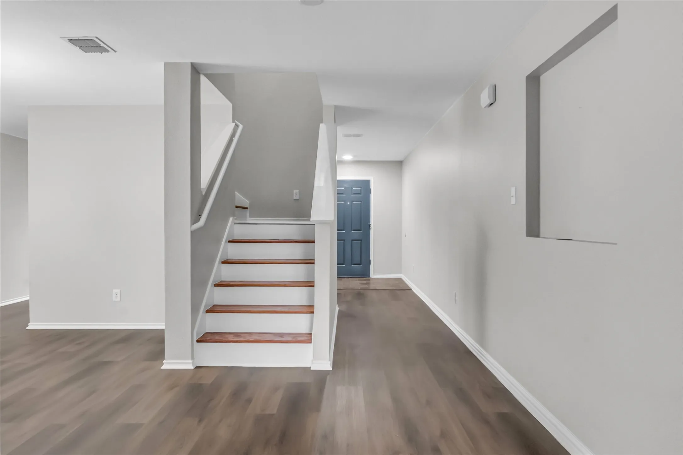 Wood-finish flooring throughout, with a contrasting wood tread staircase