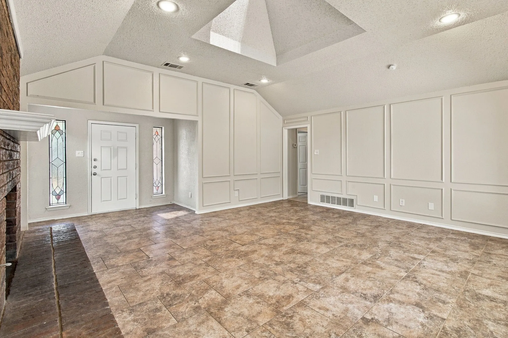 Vaulted ceiling with recessed lighting and skylight