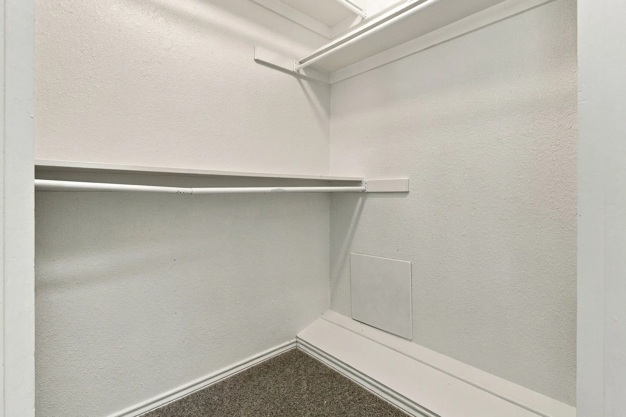 Built-in shelving and hanging rods within a closet space