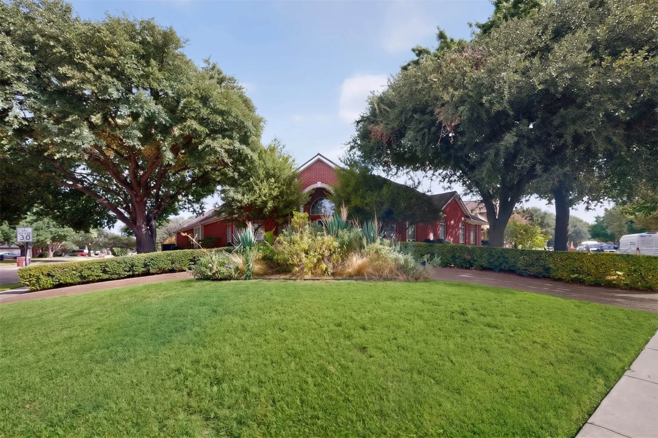 Manicured lawn with mature trees and established perimeter hedges