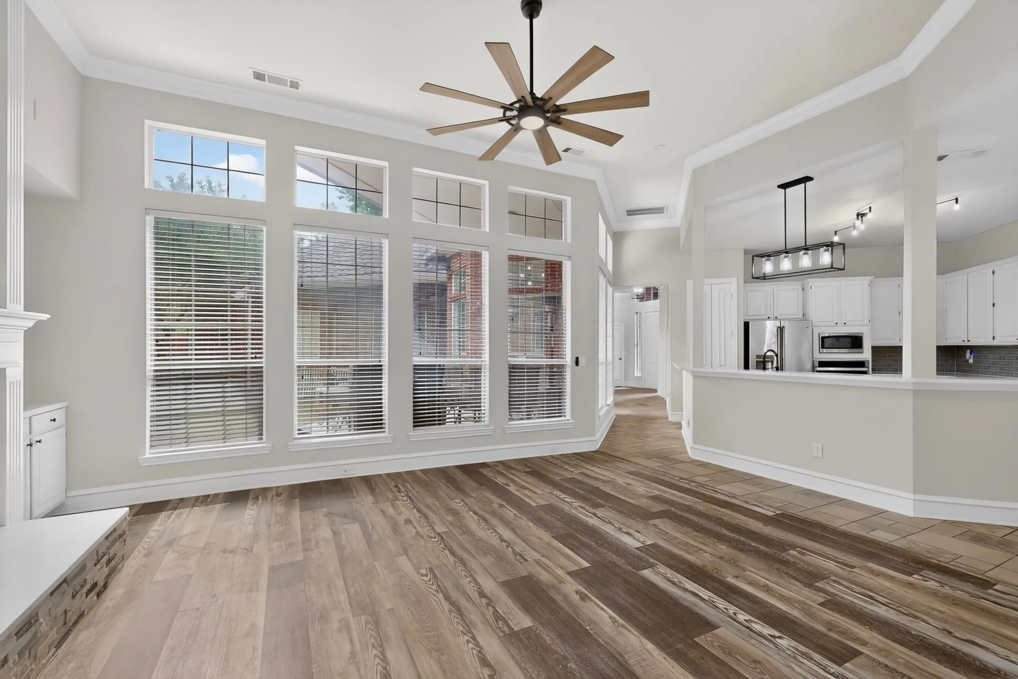 Wood-finish flooring throughout, a vaulted ceiling, and a contemporary ceiling fan