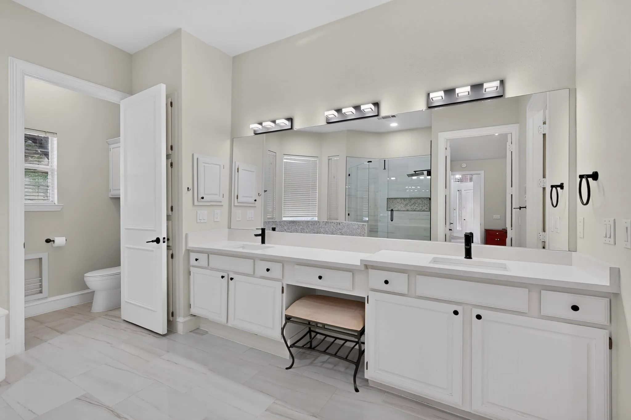 Dual vanities with white cabinetry and integrated sinks