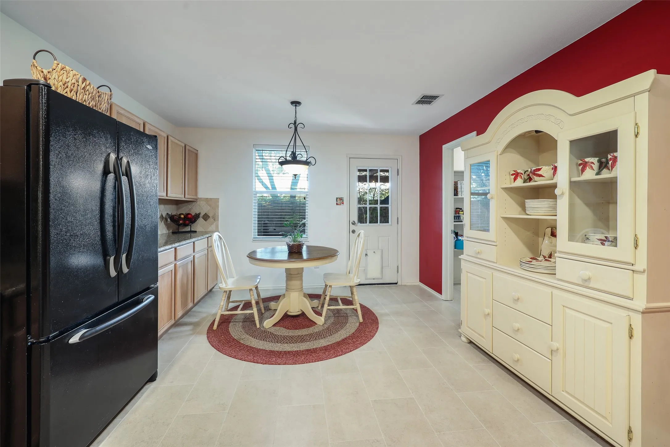 Light-toned flooring, wood cabinetry, and a kitchen window