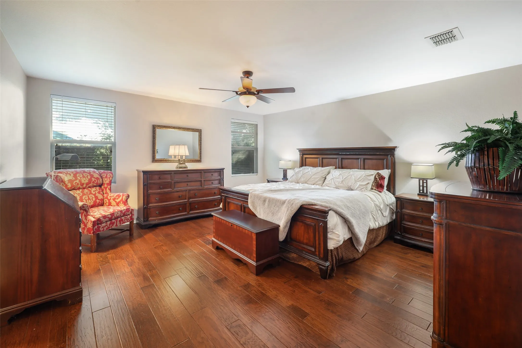 Recessed lighting, wood-finish flooring, ceiling fan with integrated lighting, multiple windows, and neutral wall tones