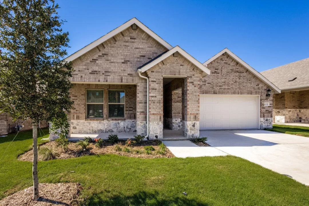 Brick exterior with stone accents and an attached garage