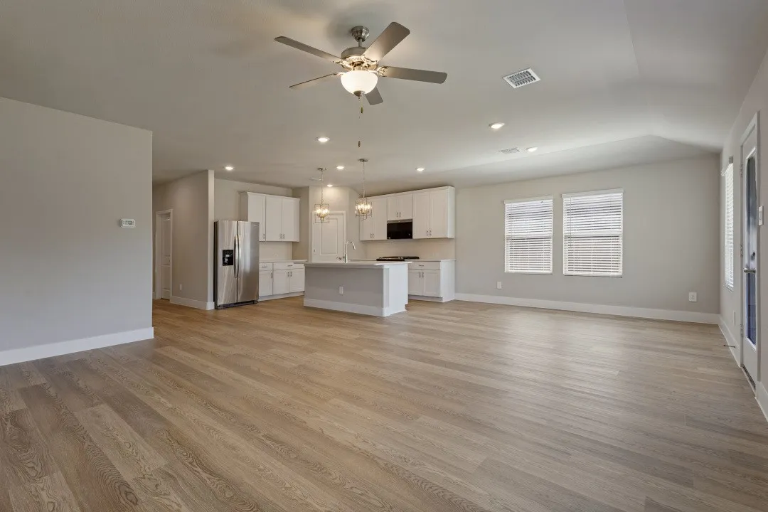Open-concept living area featuring wood-finish flooring, recessed lighting, and a ceiling fan