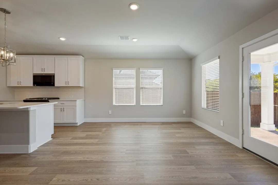 White shaker cabinetry, recessed lighting, wood-finish flooring, full-light door, and a built-in microwave
