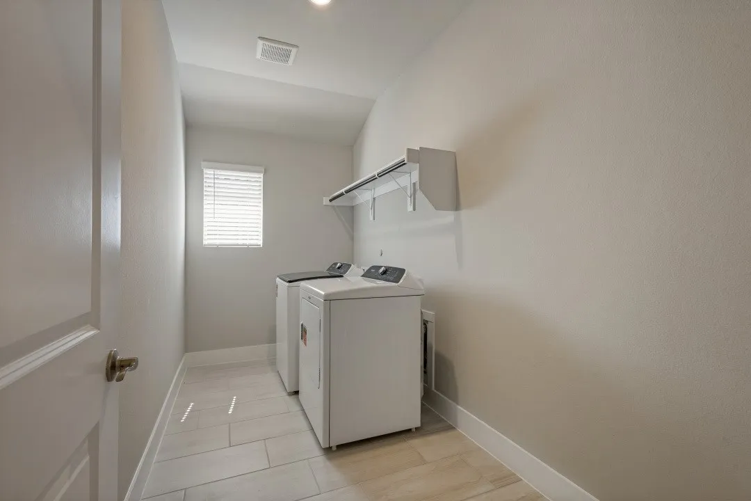 Laundry area featuring light-toned walls, tiled flooring, and a ceiling-mounted light fixture