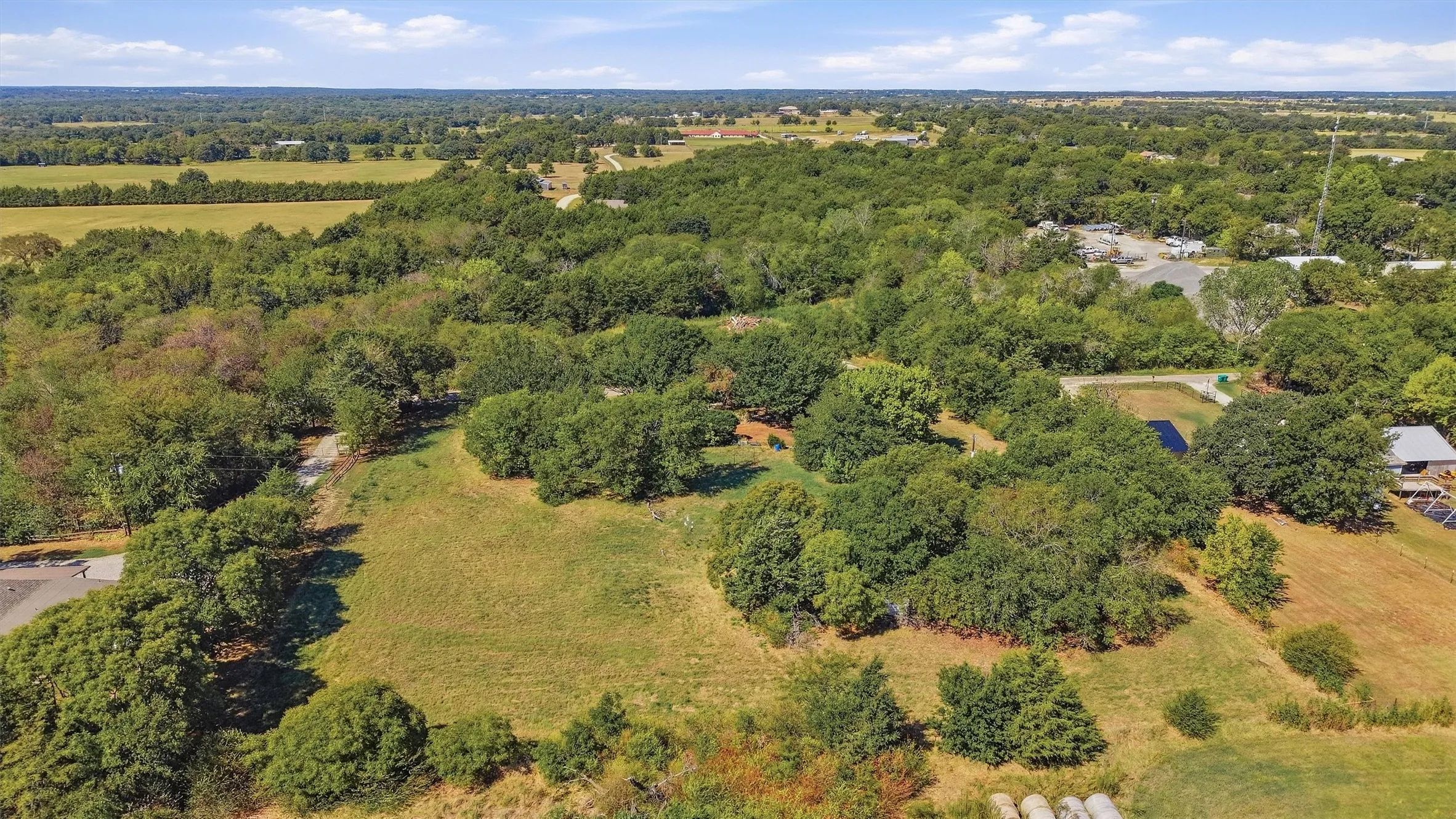 Expansive treed lot with open clearings, surrounded by additional mature trees