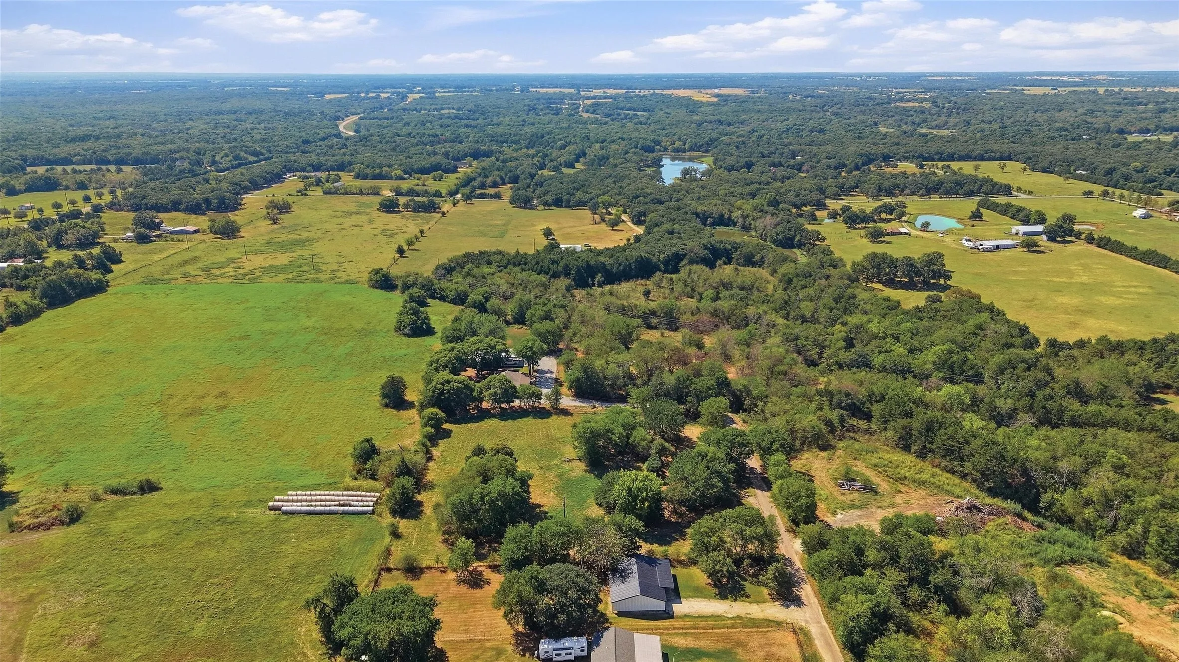 Expansive rural landscape featuring a mix of open pastures and dense woodlands