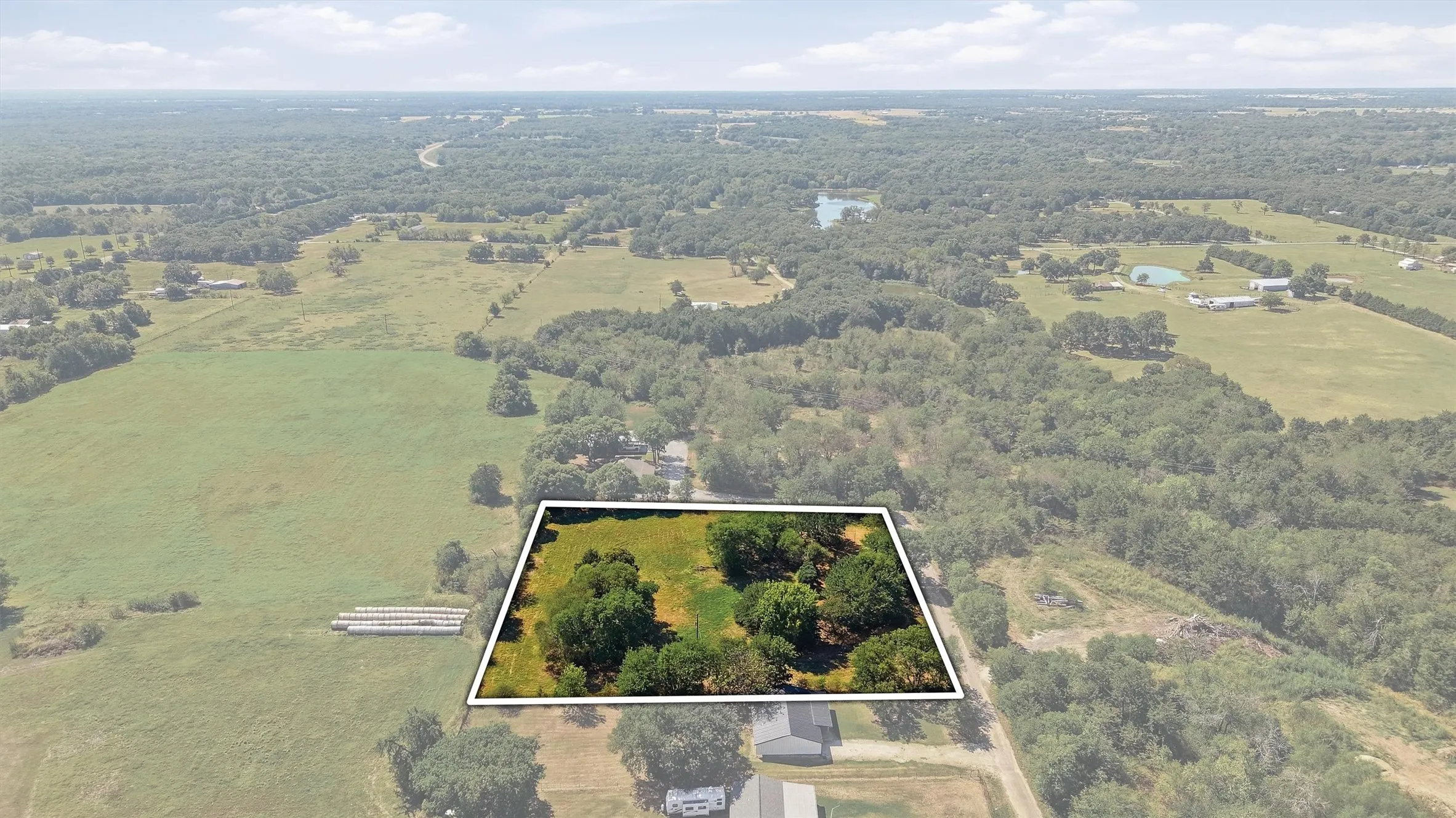 Expansive property featuring a mix of open fields and mature trees