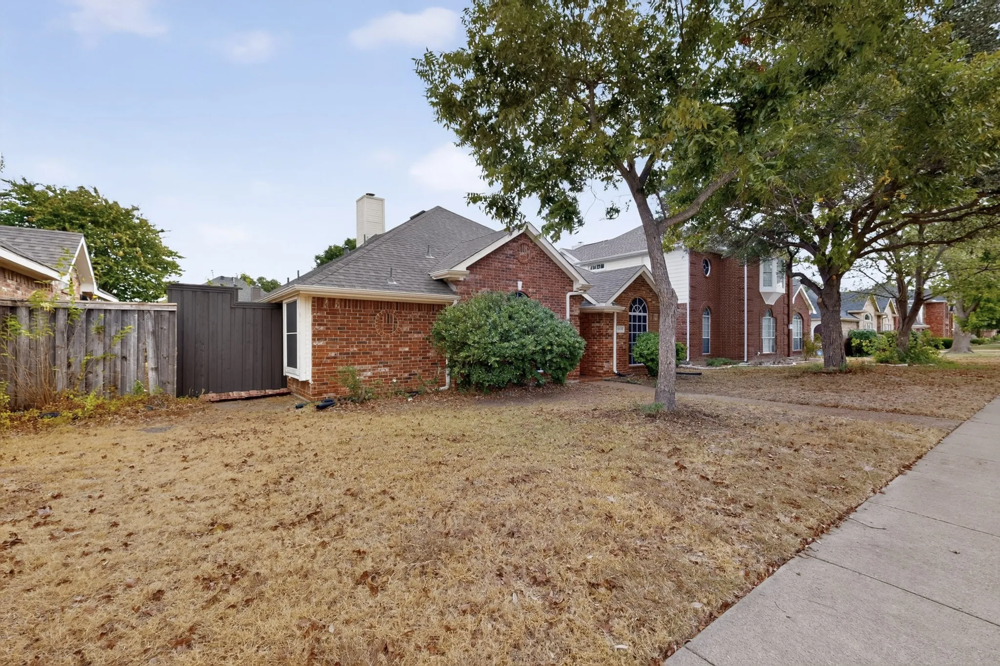 Red brick exterior with white trim, arched window, and a gabled roof