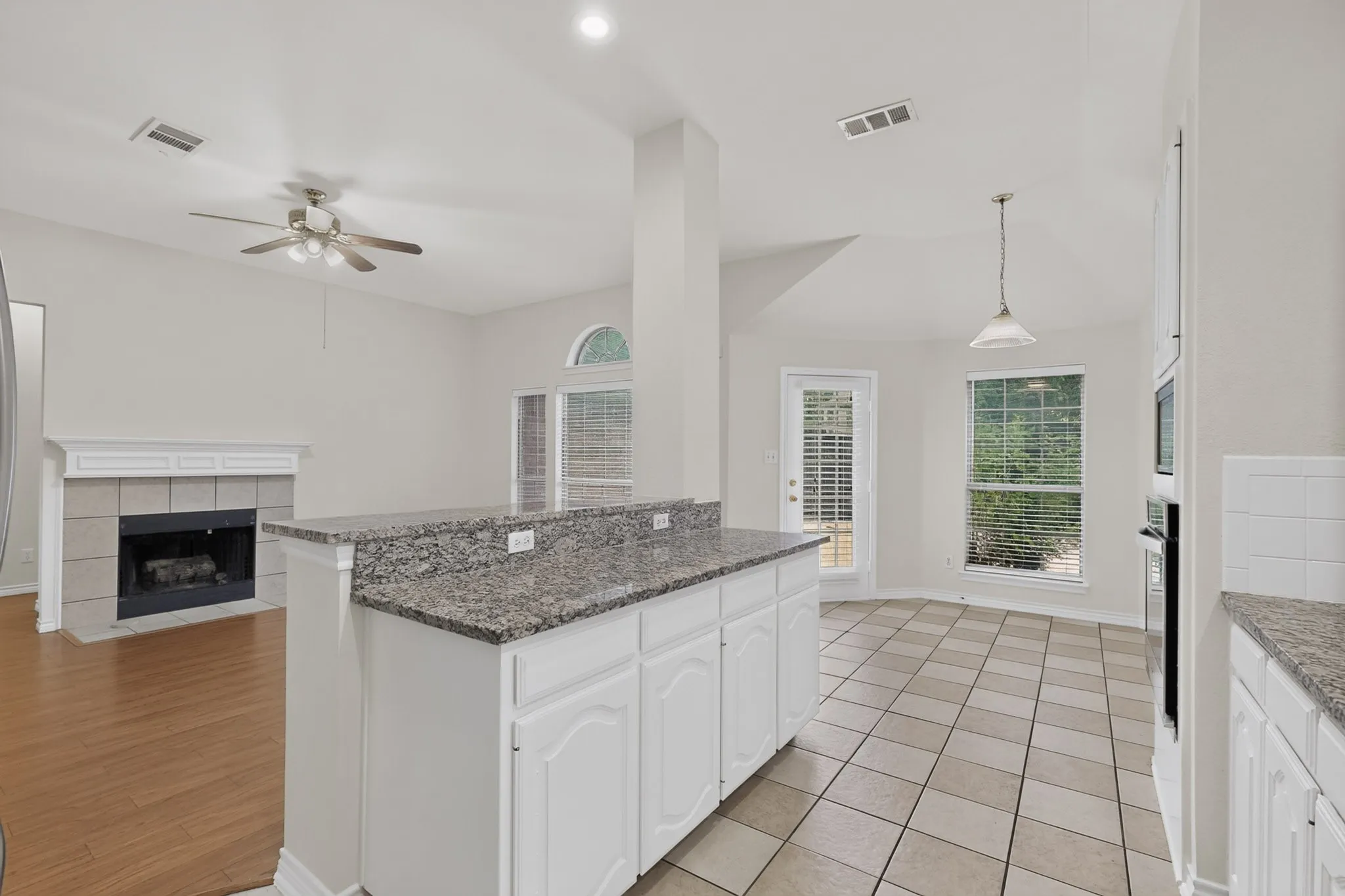 Kitchen island featuring a granite countertop and white cabinetry