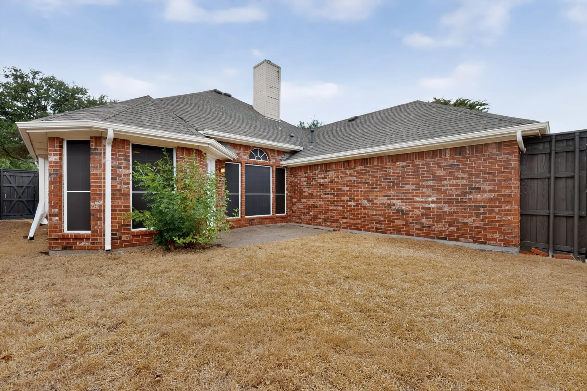 Brick exterior with a shingle roof and white gutters