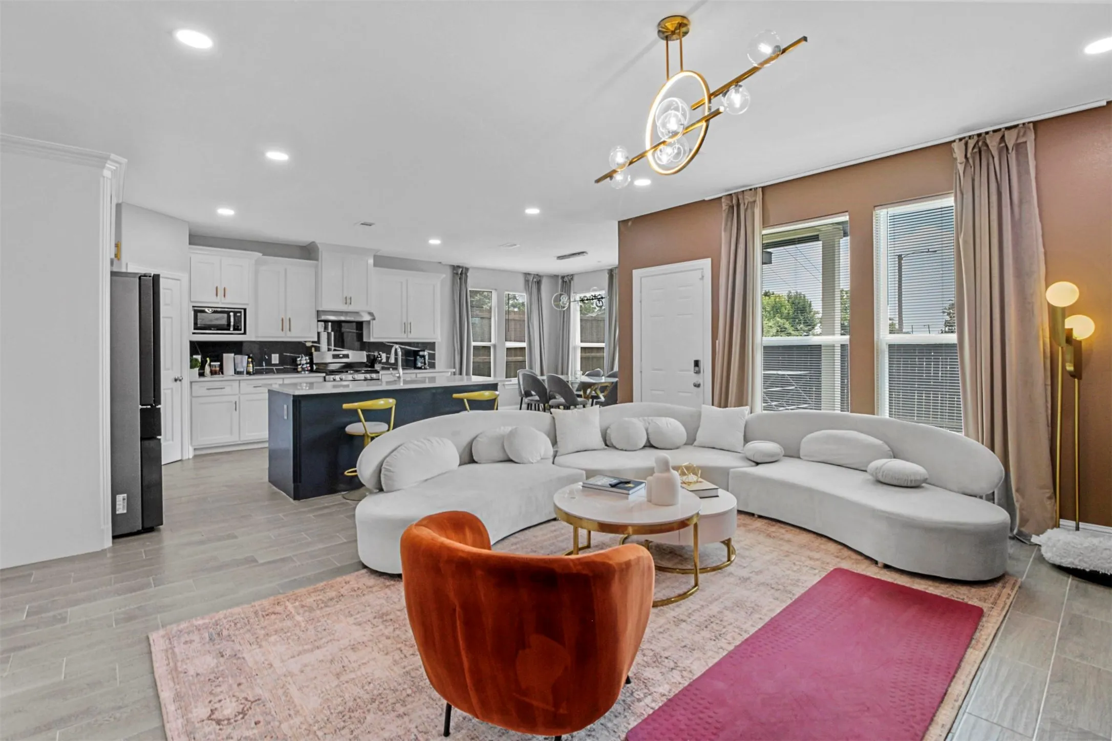 Open-concept living area with wood-finish flooring, recessed lighting, and a contemporary chandelier