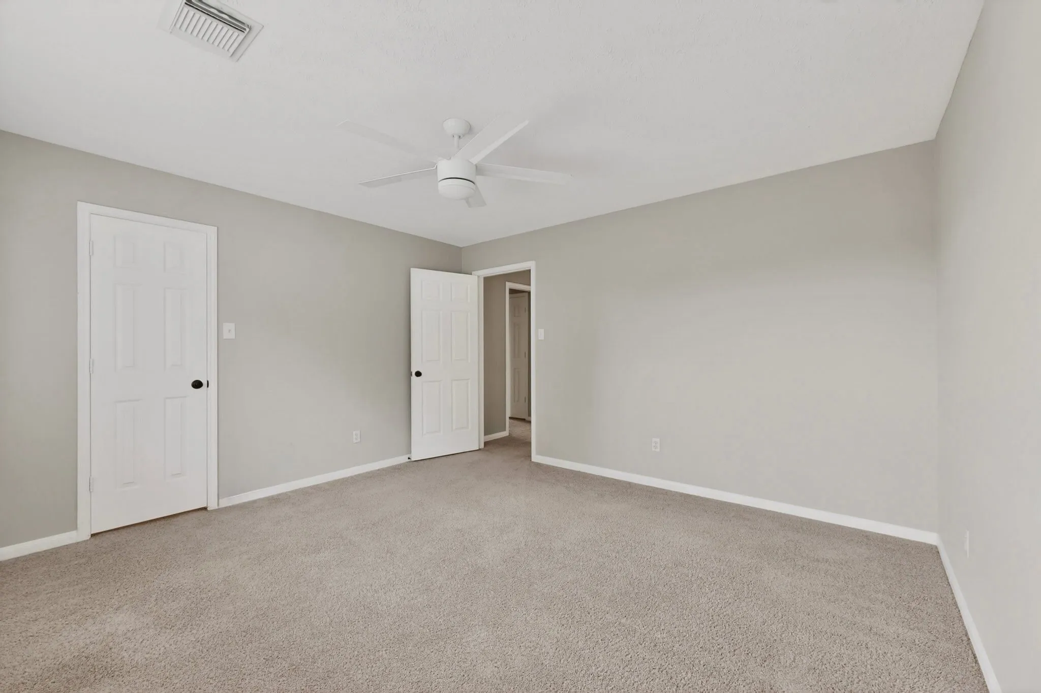 Neutral-toned walls complement plush carpeting
