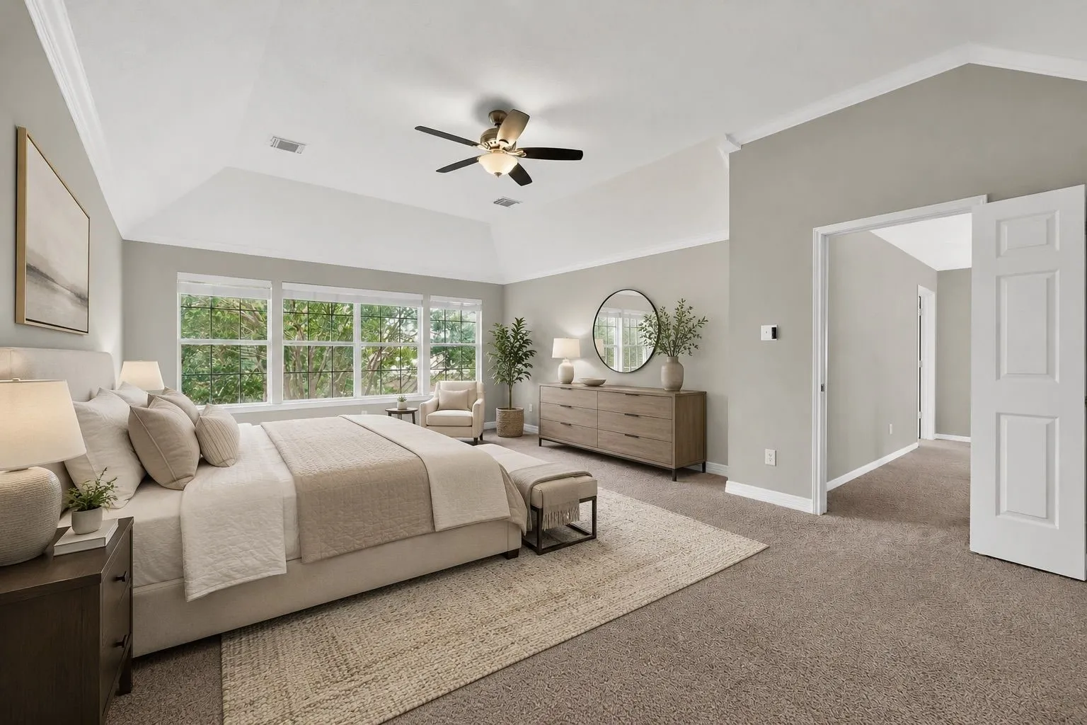 Vaulted ceiling with a ceiling fan, wall-to-wall carpeting, multiple windows, and a panel door