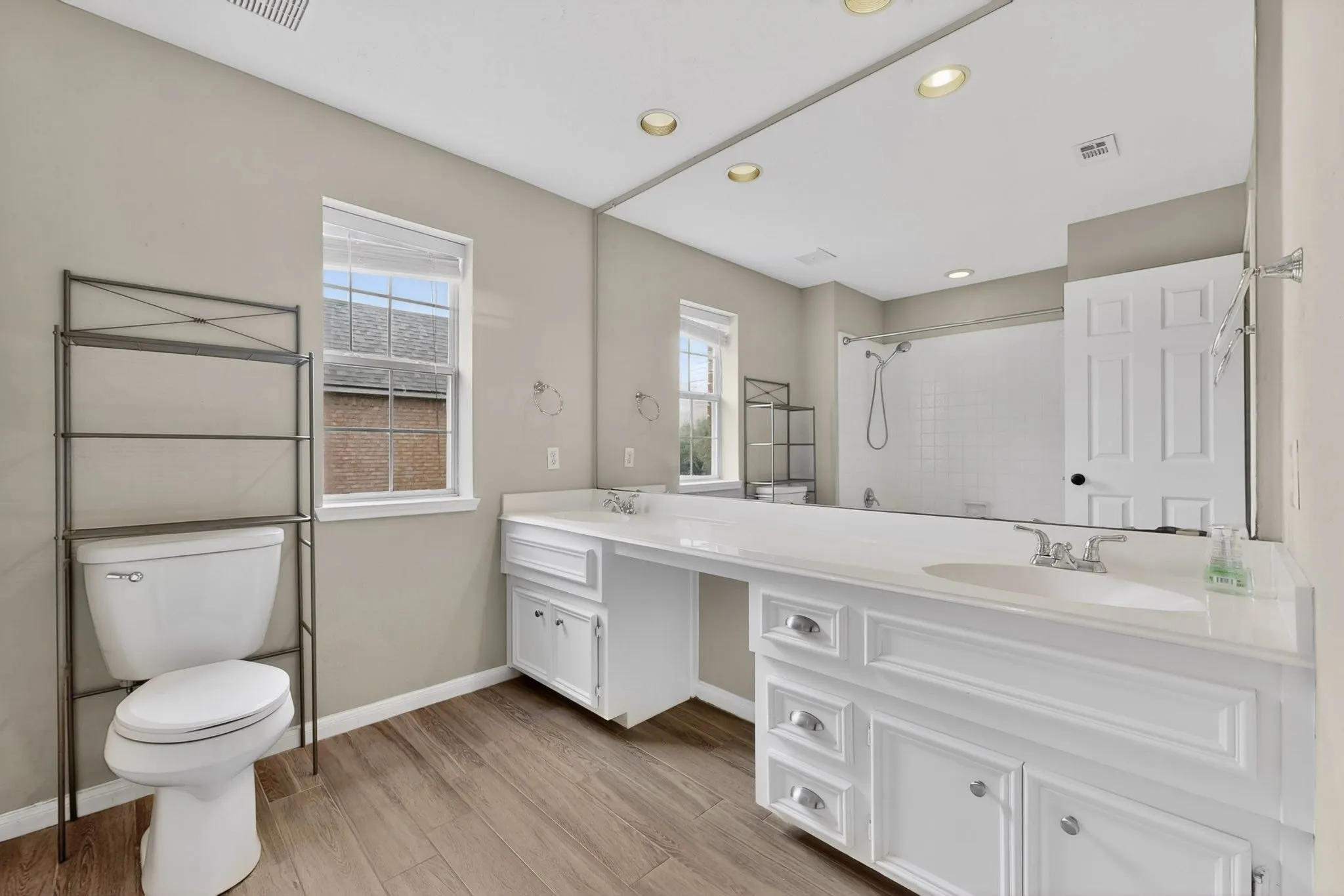 Dual vanity with white cabinetry, wood-finish flooring, recessed lighting, and a built-in shower/tub combination