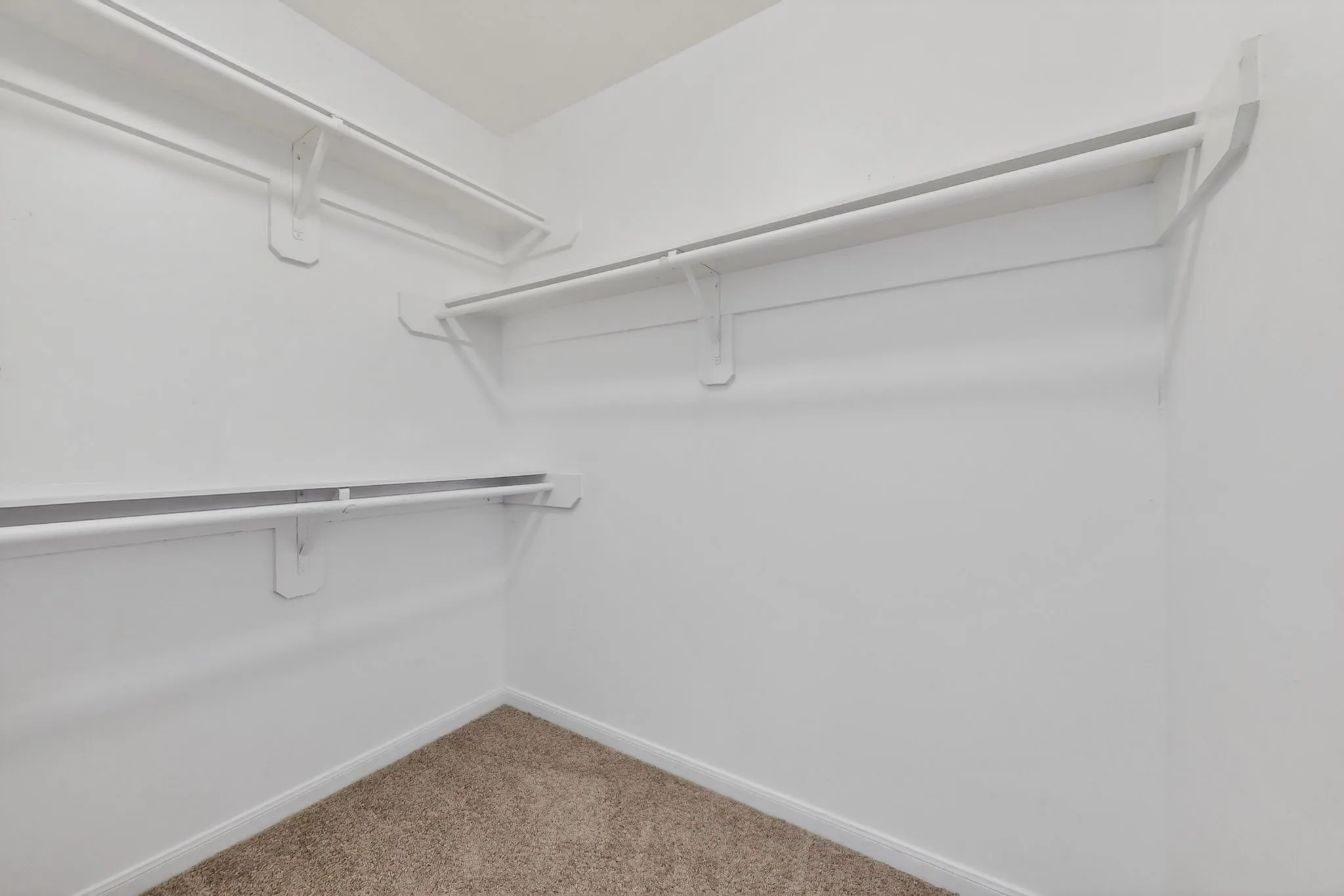 Walk-in closet featuring built-in shelving and hanging rods