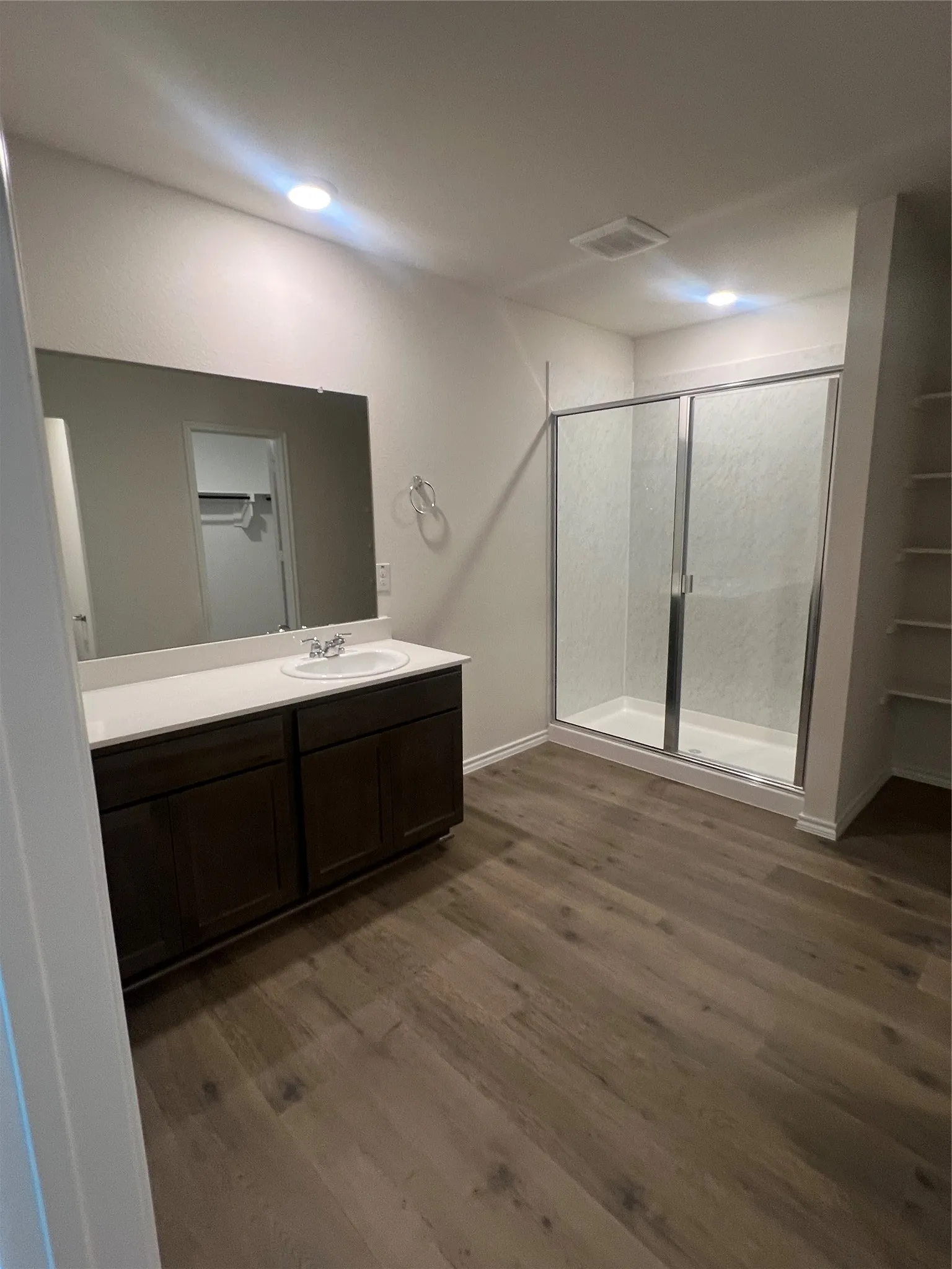 Bathroom with vanity, a stall shower, and dark wood finished floors