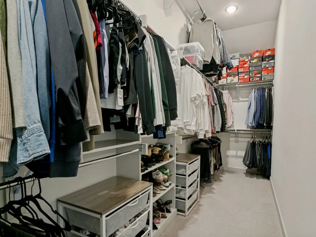 Walk-in closet with recessed lighting, integrated shelving, multiple hanging rods, and built-in storage units