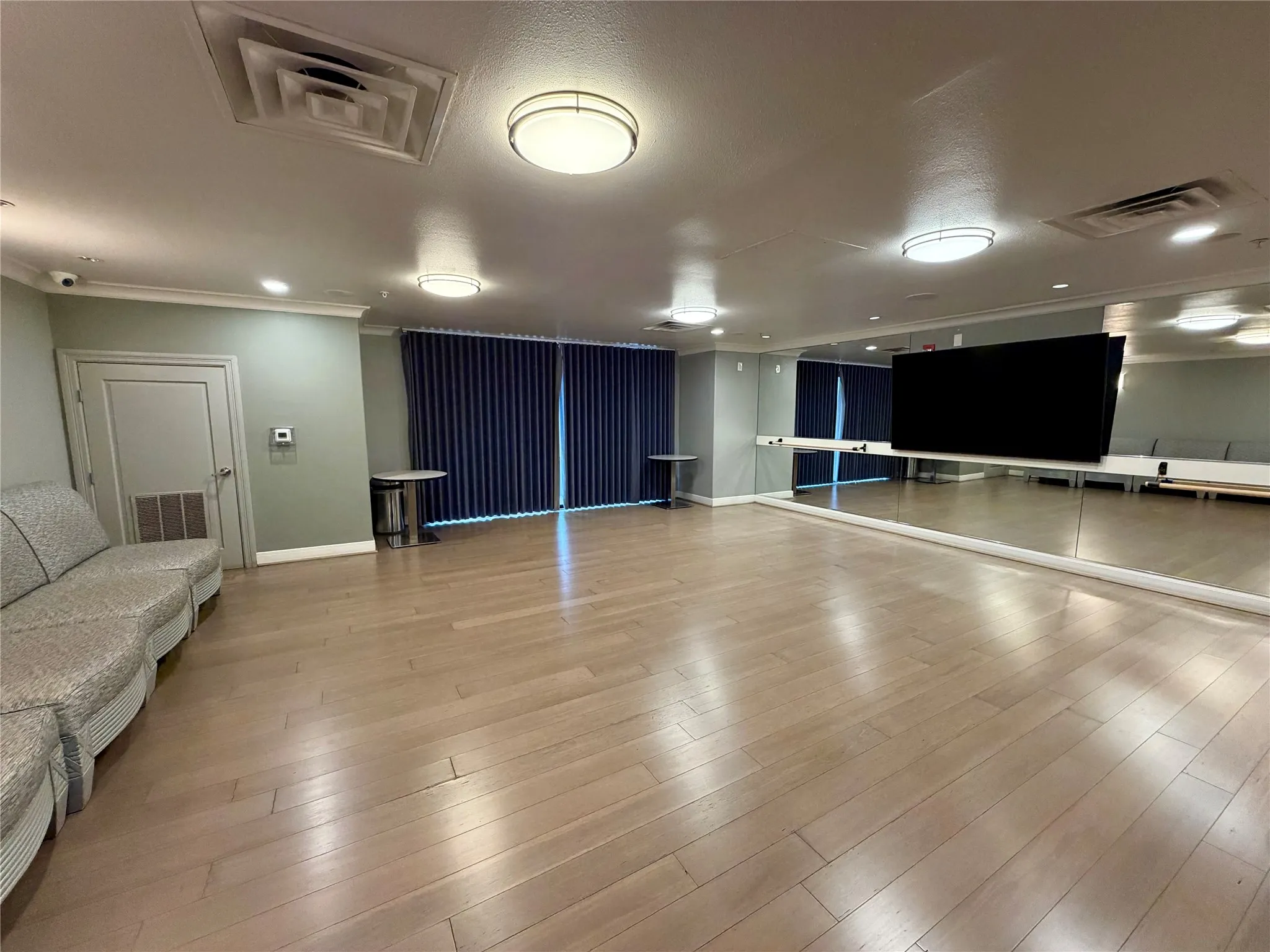 Hardwood-style flooring, full-wall mirrors, recessed lighting, and modern ceiling light fixtures