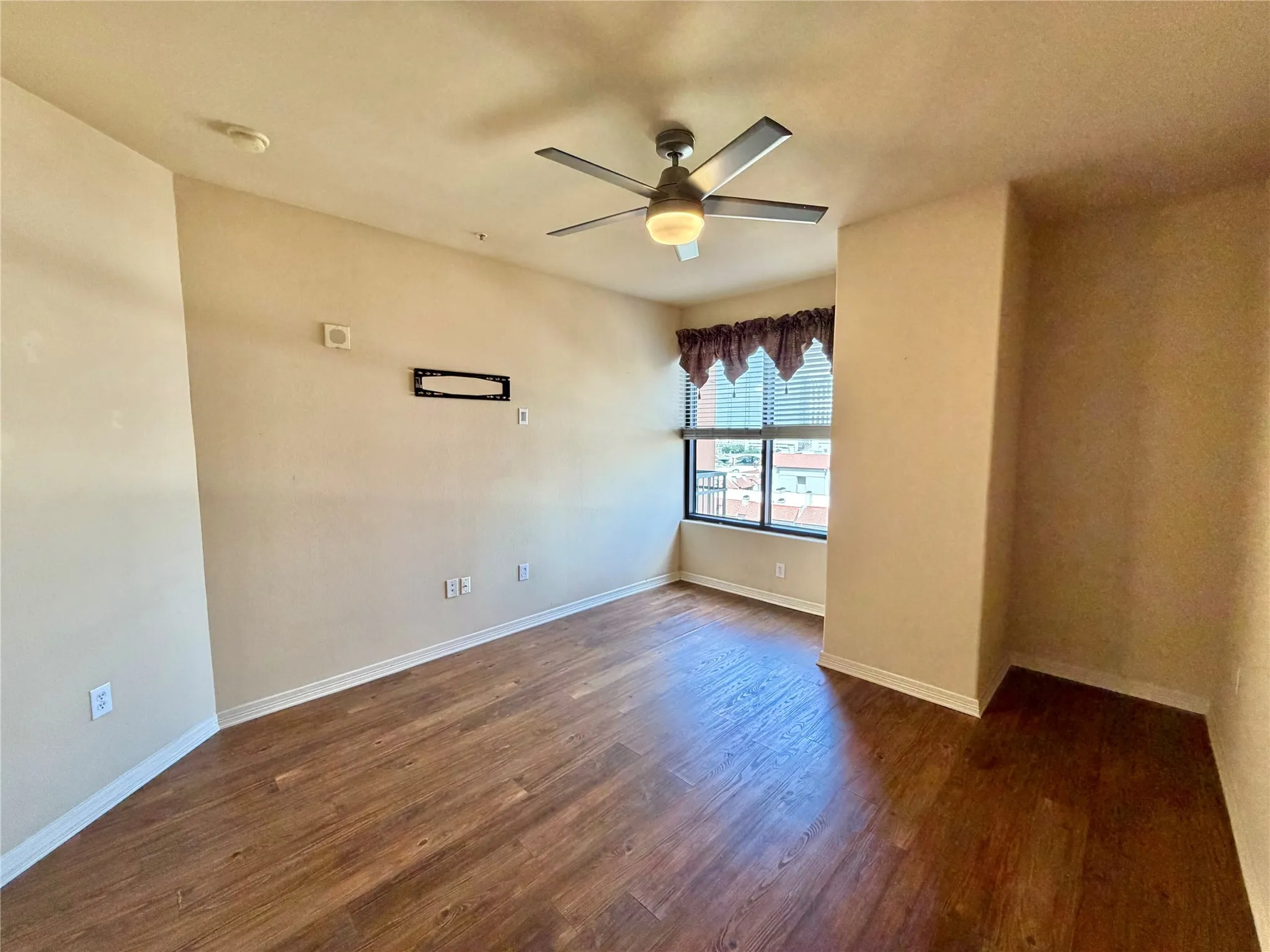 Wood-finish flooring throughout, complemented by a ceiling fan with integrated lighting