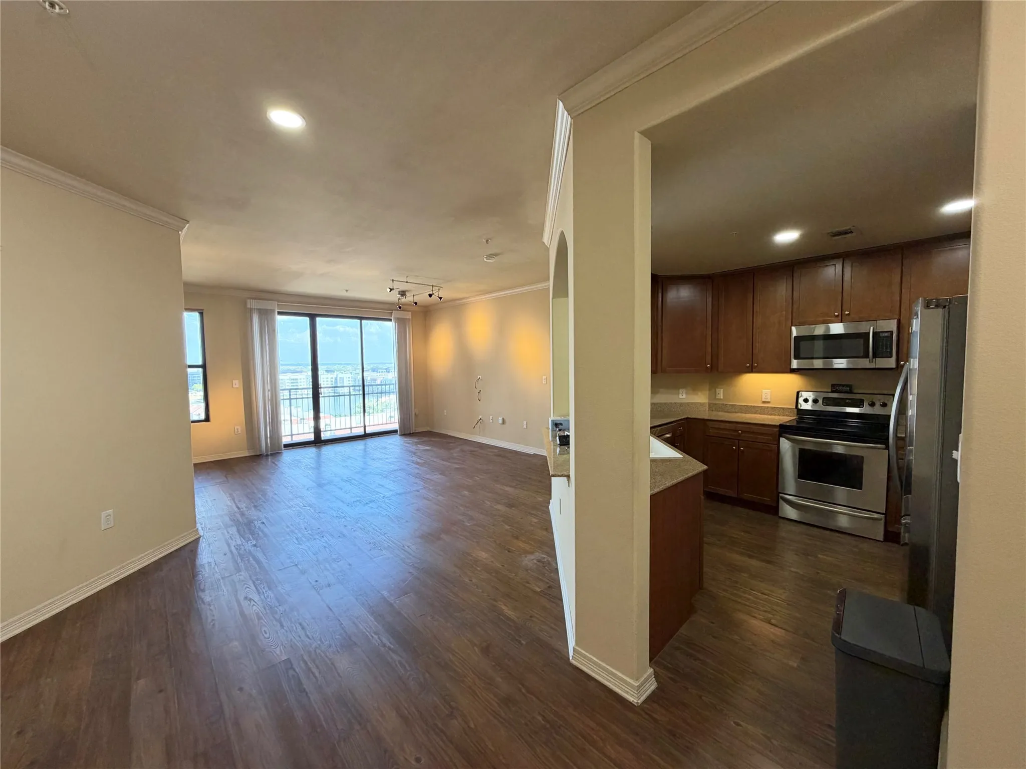 Wood-finish flooring, recessed lighting, and crown molding
