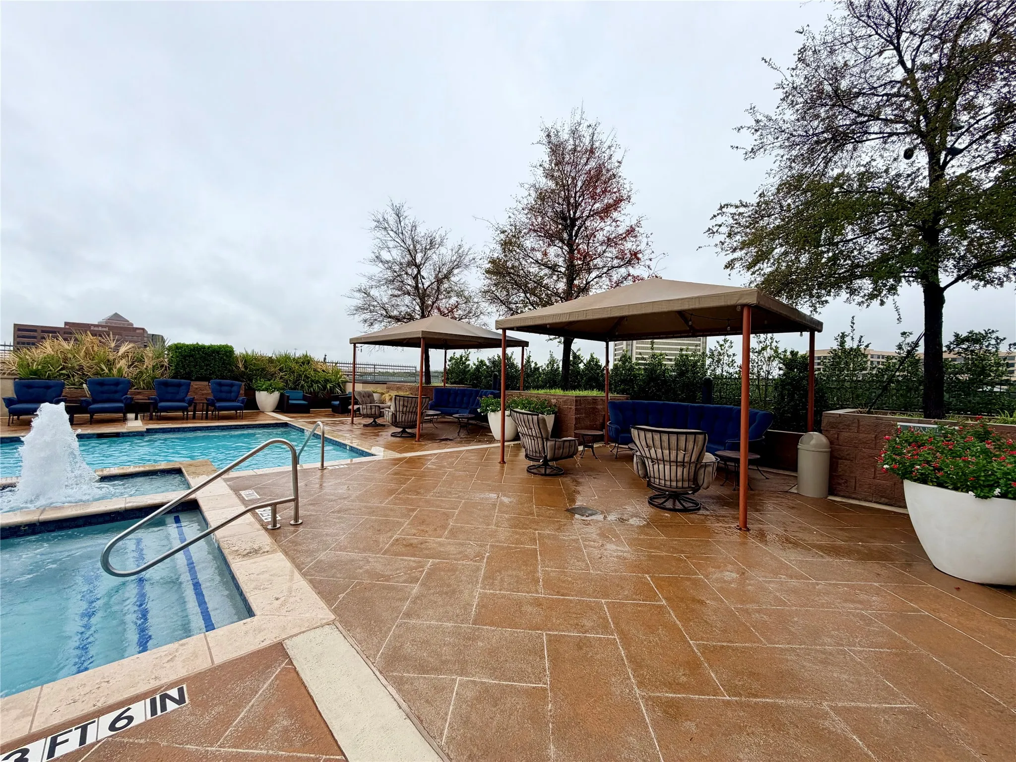 Swimming pool with an integrated spa, a water feature, and stainless steel handrails