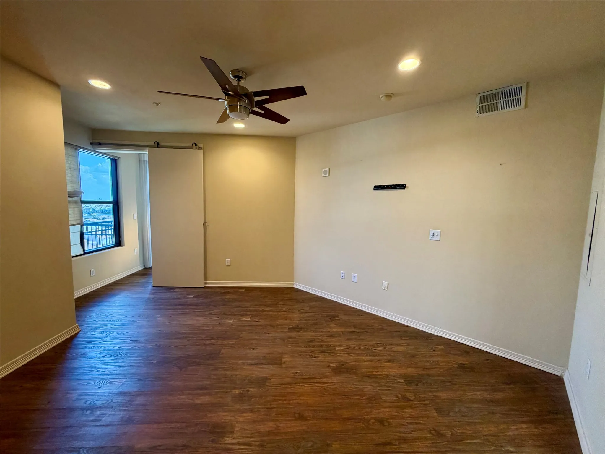 Wood-finish flooring throughout, recessed lighting, ceiling fan, and a sliding barn door