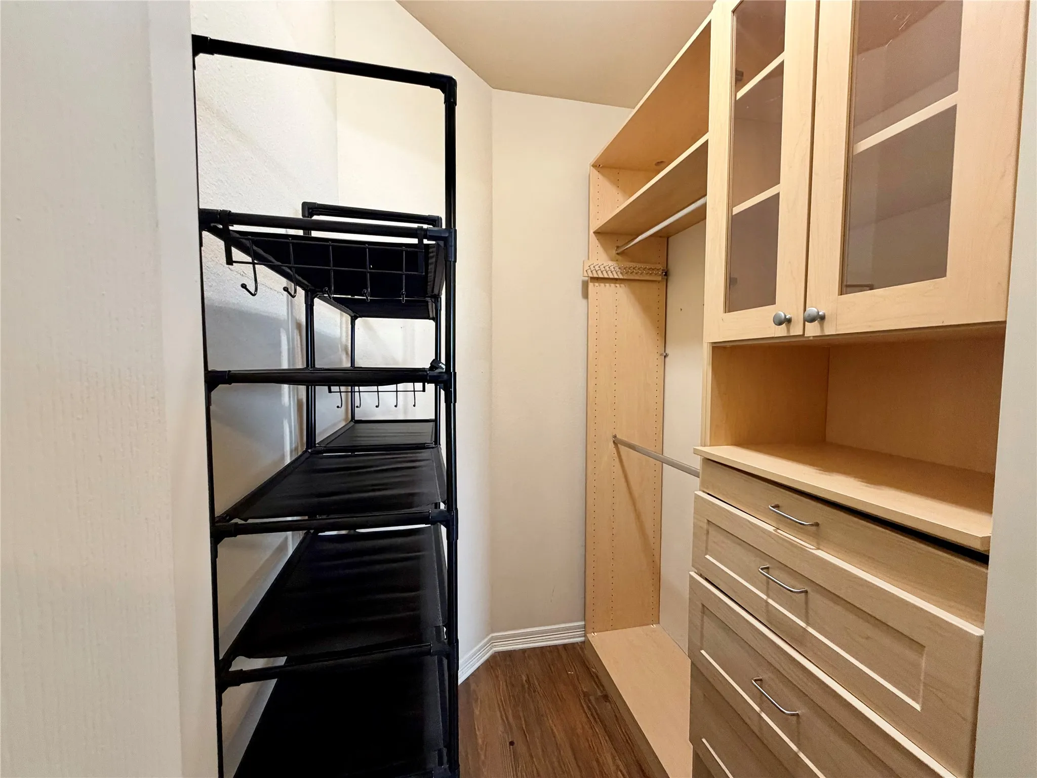 Built-in closet system featuring multiple shelves, drawers, and hanging rods