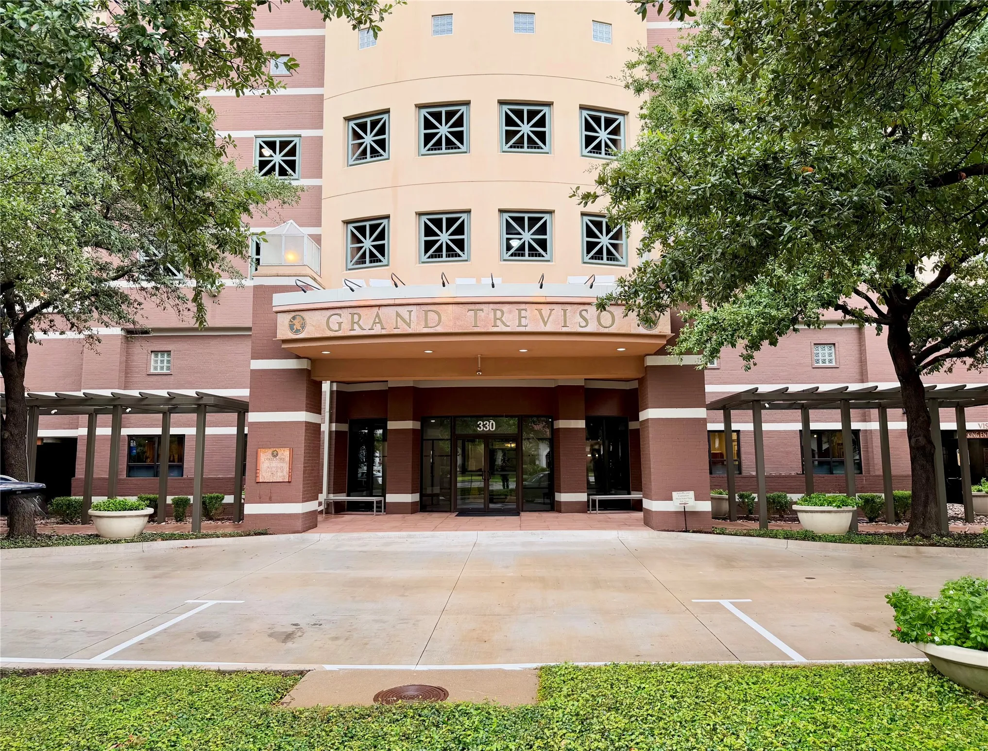 Building exterior with a prominent arched entrance, dual automatic glass doors, and a decorative signage above