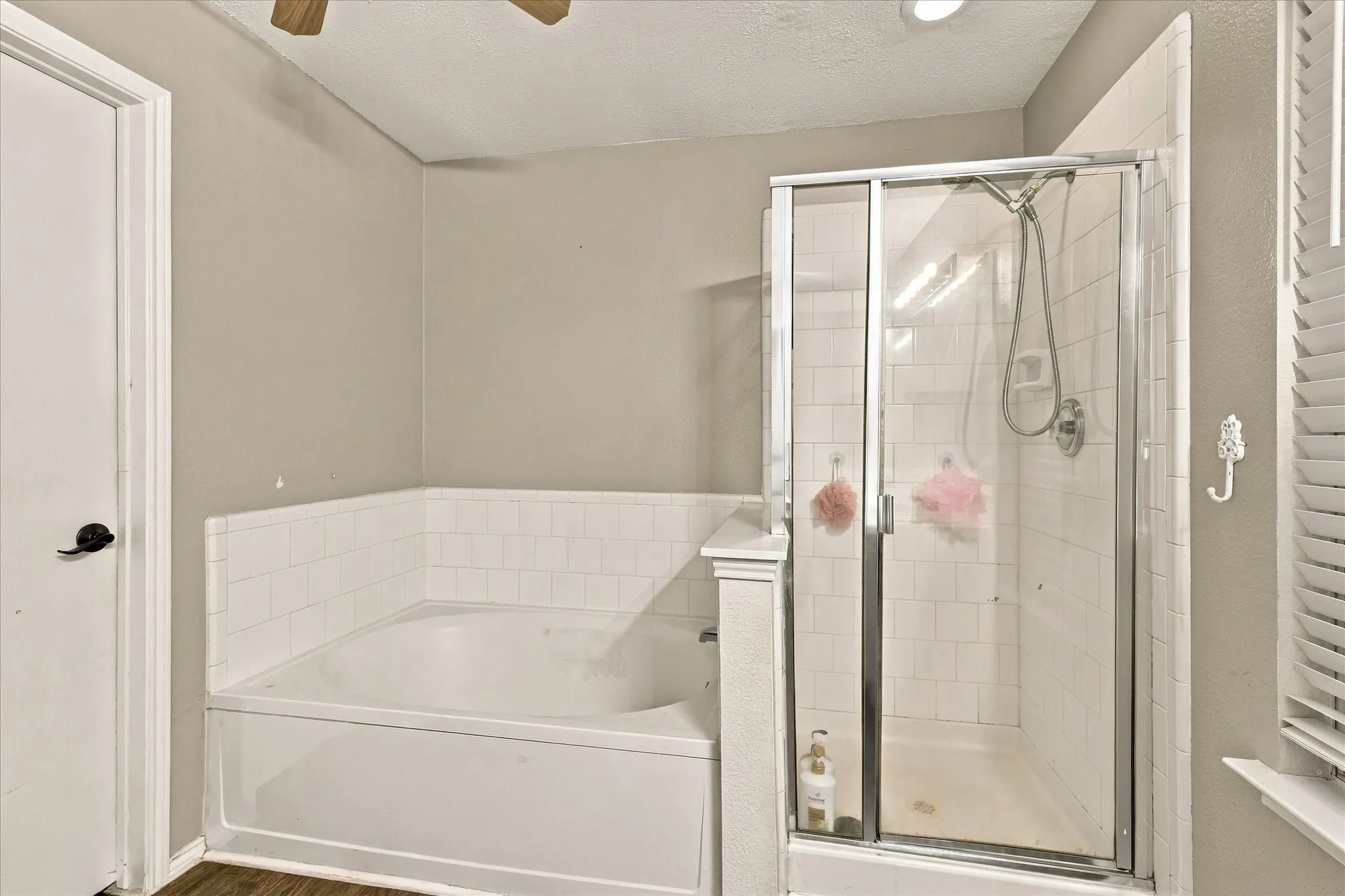 White tiled bath and shower combination with glass enclosure