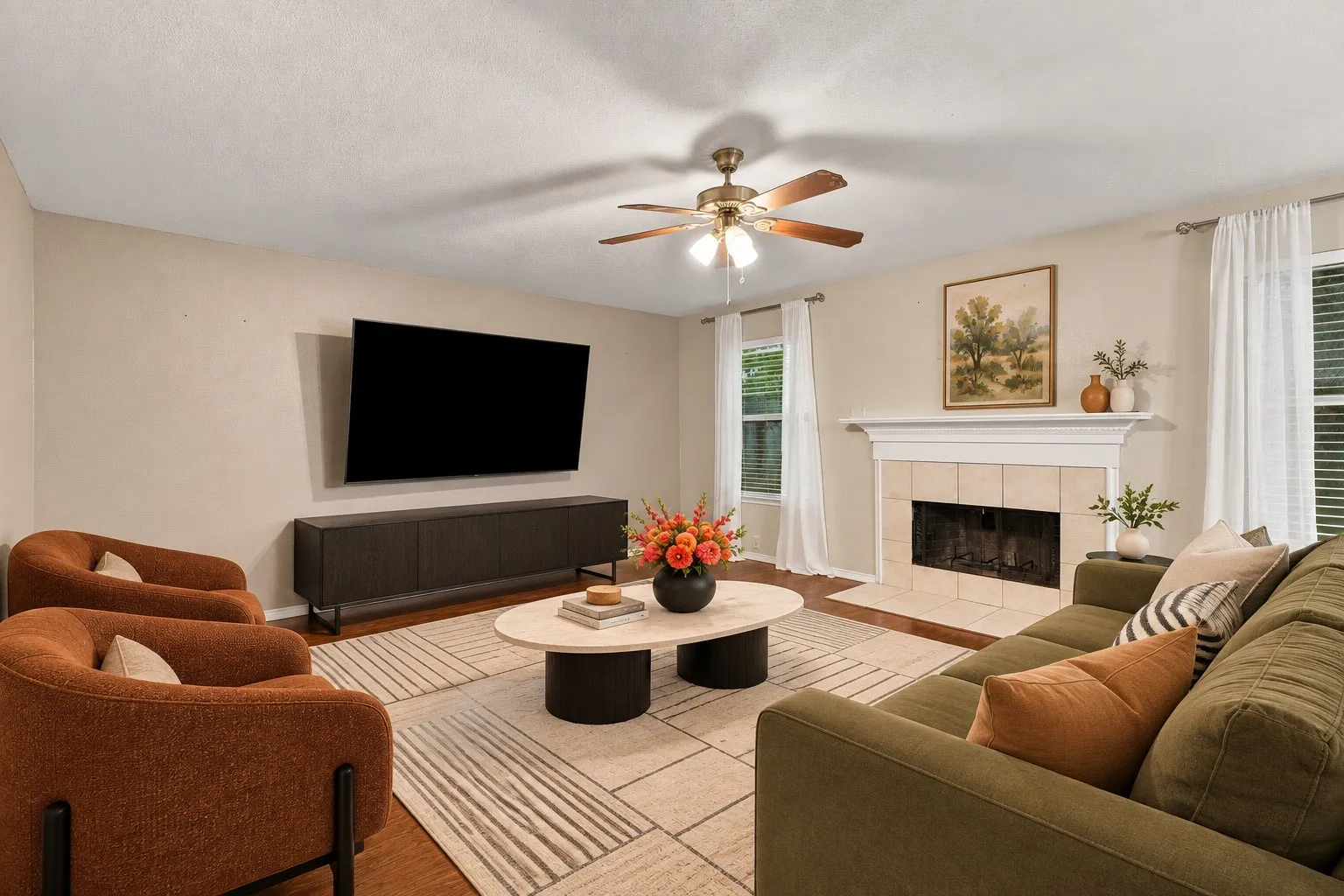 Virtually Staged Wood-finish flooring, ceiling fan, fireplace with tile surround, and multiple windows
