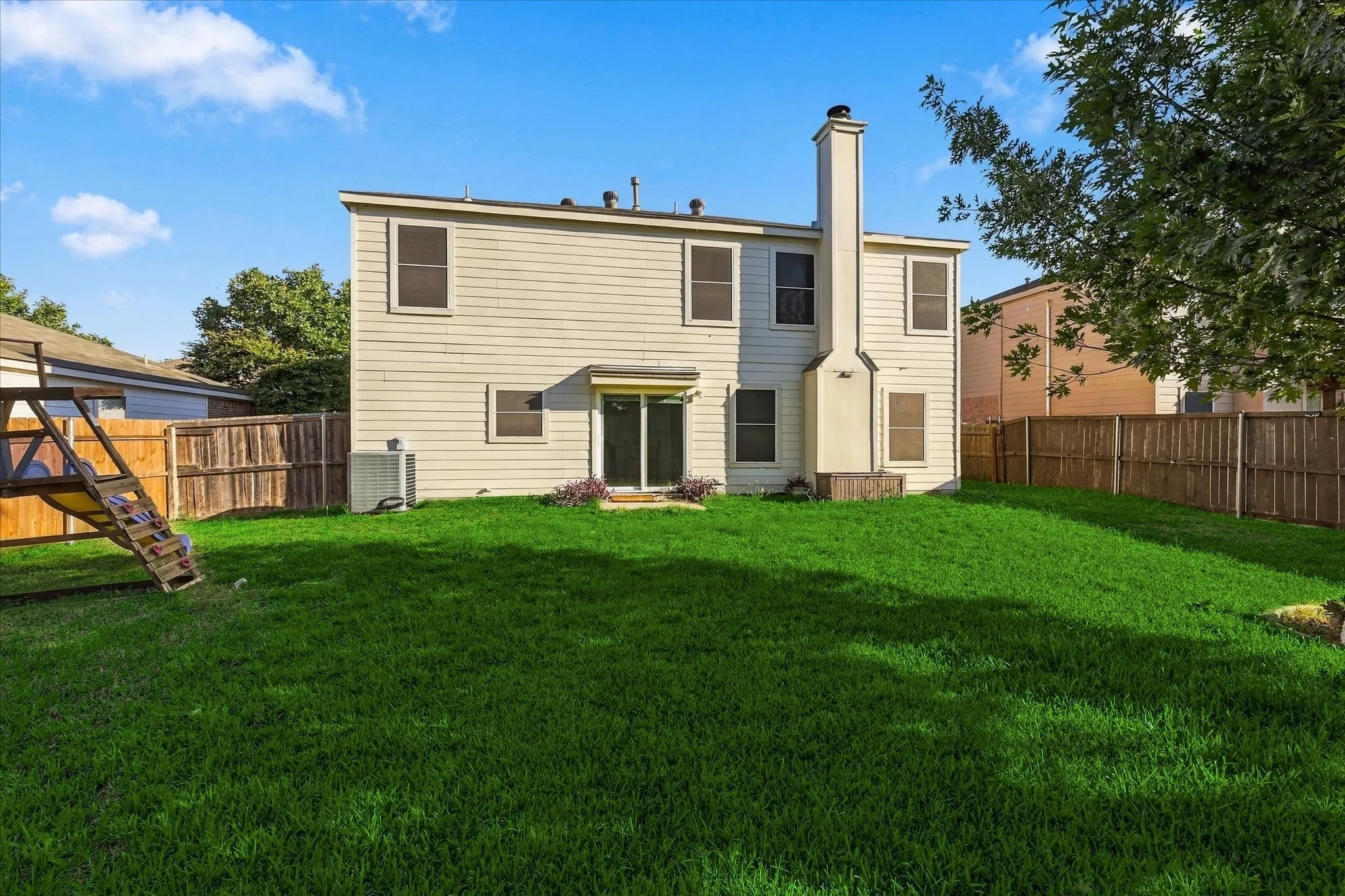 Expansive fenced backyard with a large grass lawn